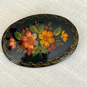 Oval hand painted dated 1992 signed black with floral design brooch